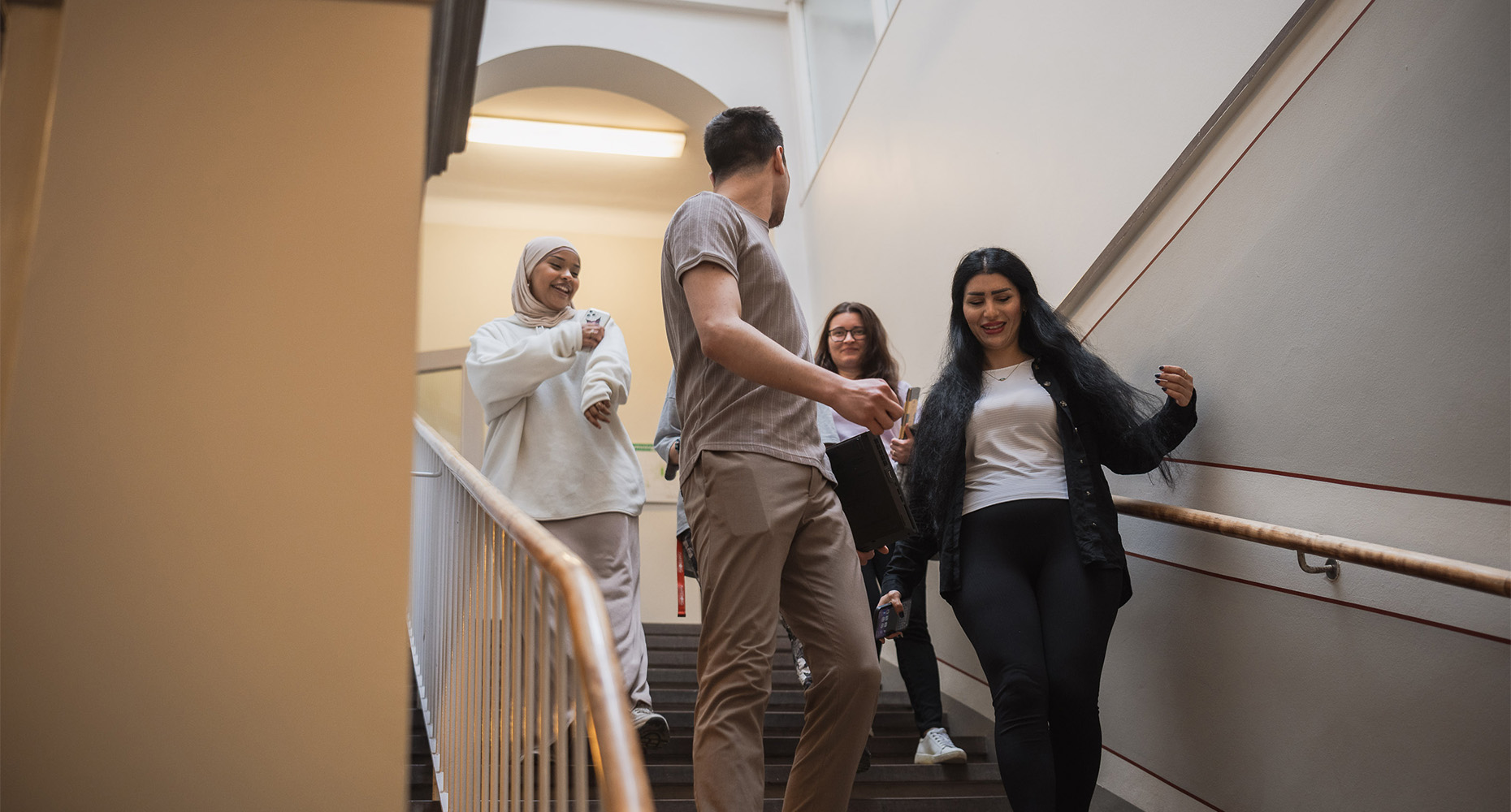 Deltagare på kursen Tema människan går tillsammans i trapphuset i skolbyggnaden Fröbel